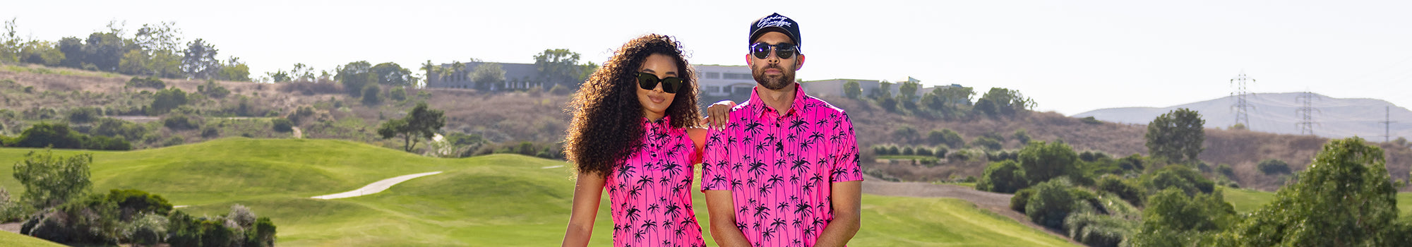 An attractive couple wearing matching bright pink golf polos