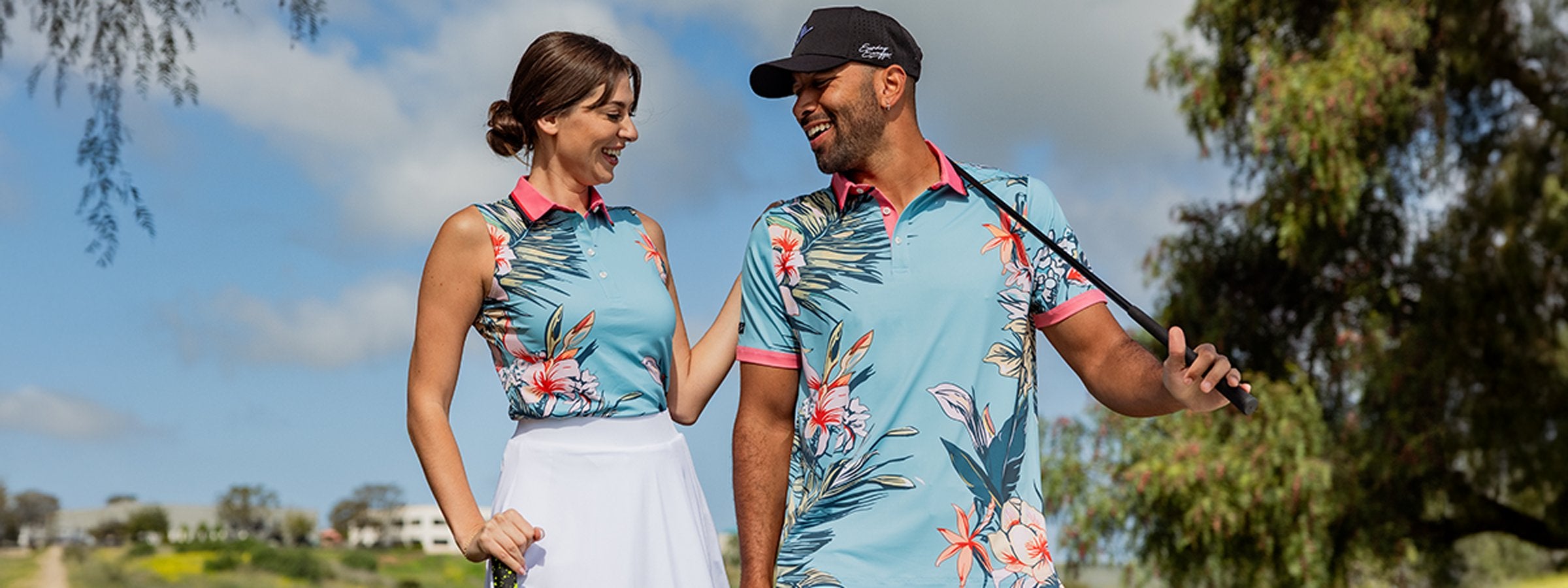 An attractive couple wearing matching bright pink golf polos