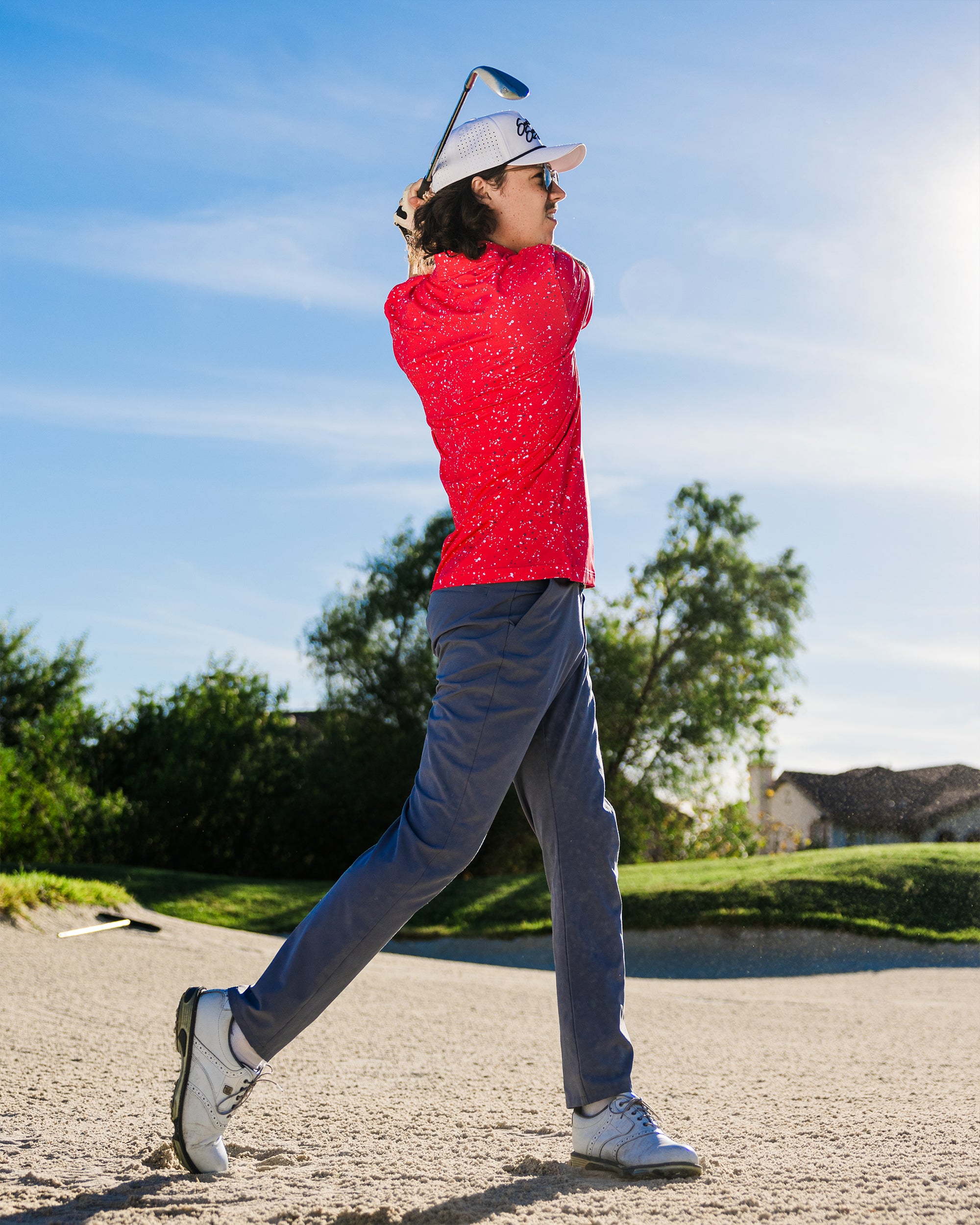 Man swinging a golf club wearing Sunday Swagger's Gnarly golf polo